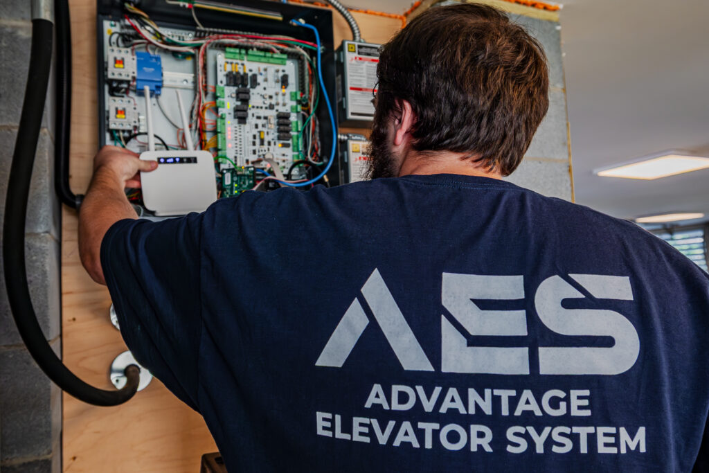 Technician performing annual home elevator maintenance inspection on key systems.